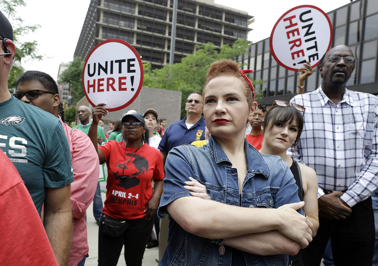 In this June 27 photo, Amanda Hammock (center), a Delaware County, Pennsylvania Democratic party activist, is dressed as Rosie the Riveter as she attends a protest by Philadelphia Council AFL-CIO in Philadelphia. (AP Photo/Jacqueline Larma)