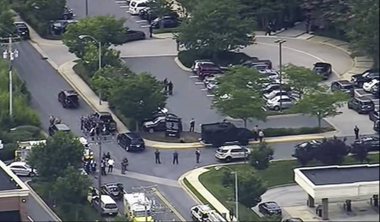 In this frame from video, people leave the Capital Gazette newspaper after multiple people have been shot on Thursday in Annapolis, Maryland. (WJLA via AP)