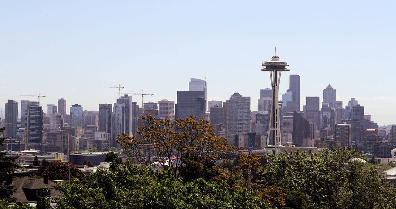 In this May 22 photo, a floor of scaffolding remains below the upper portion of the Space Needle as construction cranes rise above downtown behind in Seattle. (AP Photo/Elaine Thompson)