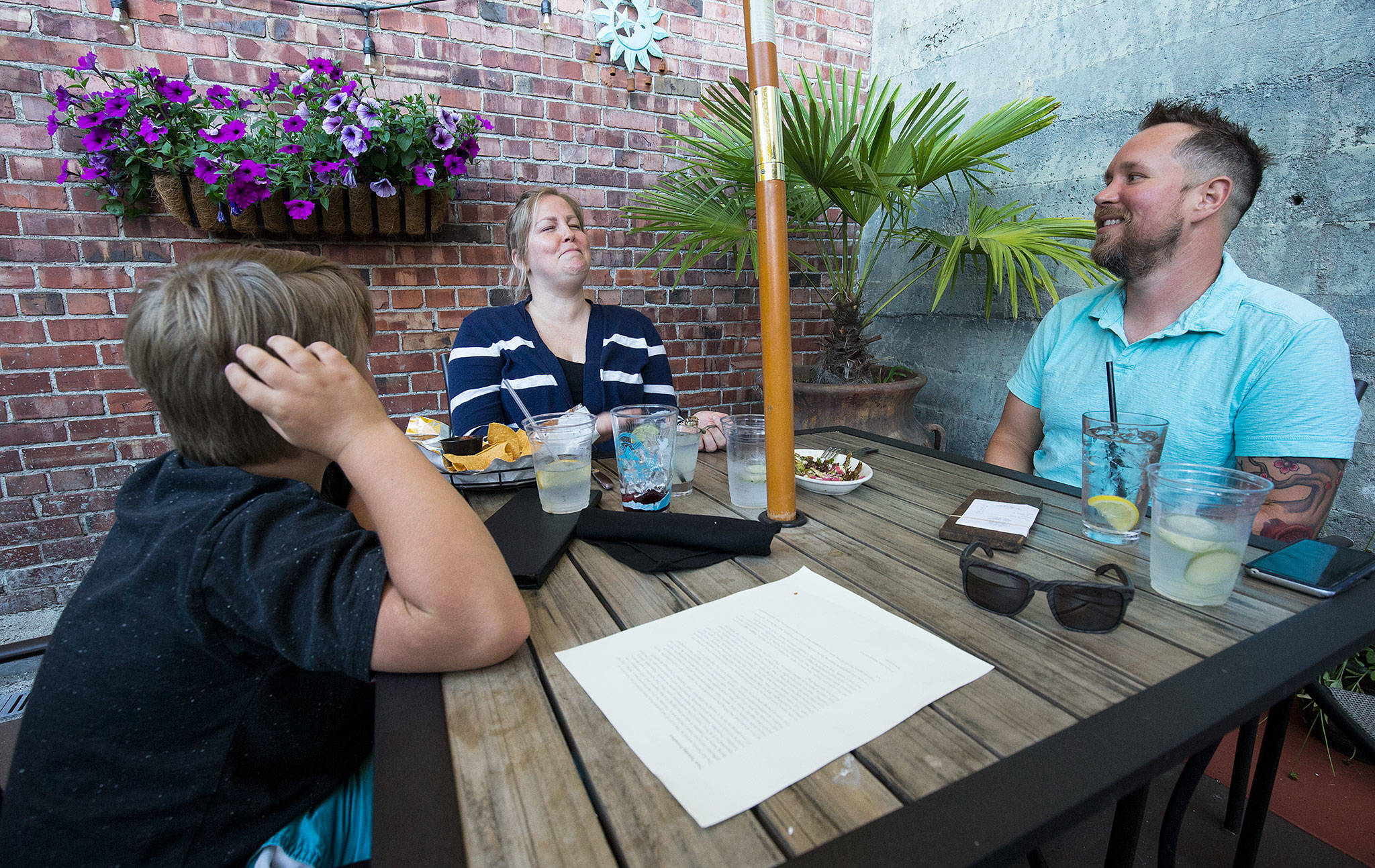 Becca Selin and her son, Brody, share a laugh with Erik Marty during Taco Tuesday at Sol Food Bar and Grill in Everett. Marty put out a question looking for a dining companion on a Facebook dining page. Within 90 minutes, Selin answered and brought along Brody, 7. (Andy Bronson / The Herald)