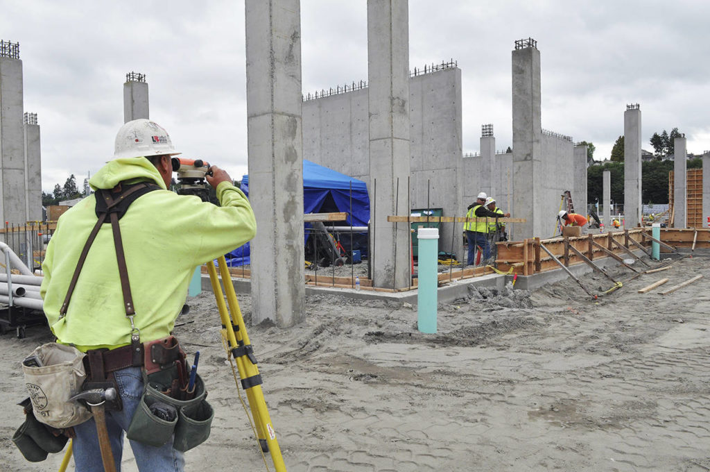 Carpenter Scott Jacobs is making sure things are level at the construction site of the Port of Everett’s Waterfront Place Central redevelopment project. (Sue Misao / The Herald)
