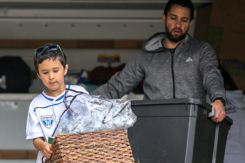 Guillermo David Jiménez, 7, and his father, Guillermo Mario Jiménez, unload the moving truck at their new home in Everett. (Kevin Clark / The Herald)
