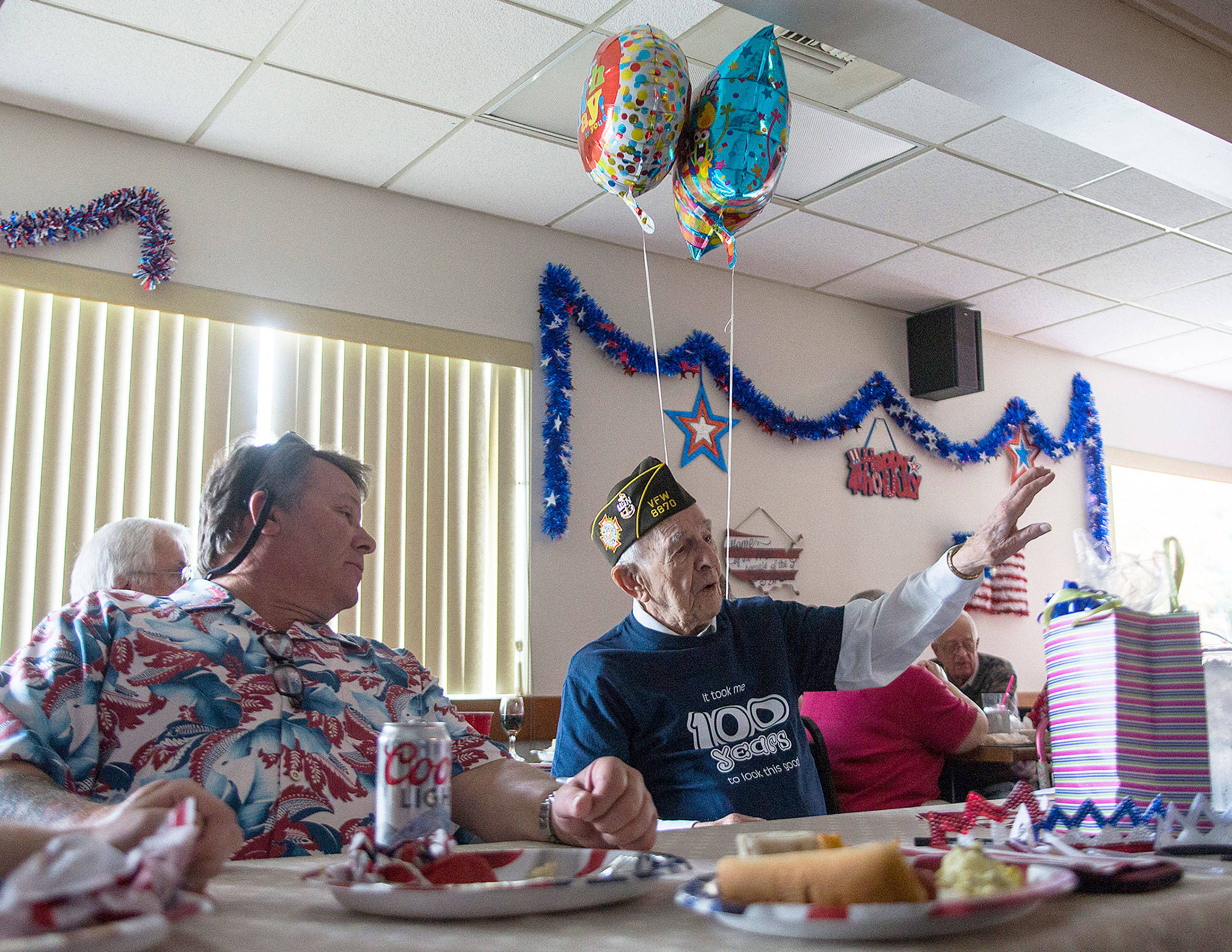 Edgar Shepherd talks to friends and family during his 100th birthday celebration at the Lynnwood Elks Lodge on Wednesday. (Olivia Vanni / The Herald)