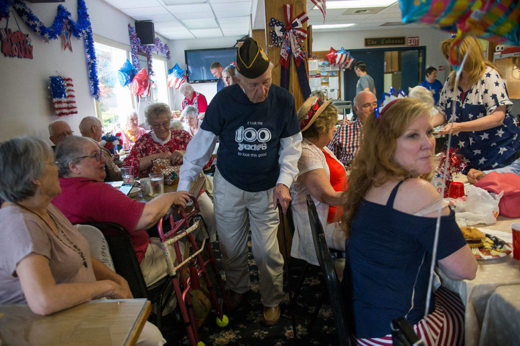Edgar Shepherd passes family members and friends at his 100th birthday celebration at the Lynnwood Elks Lodge on Wednesday. (Olivia Vanni / The Herald)
