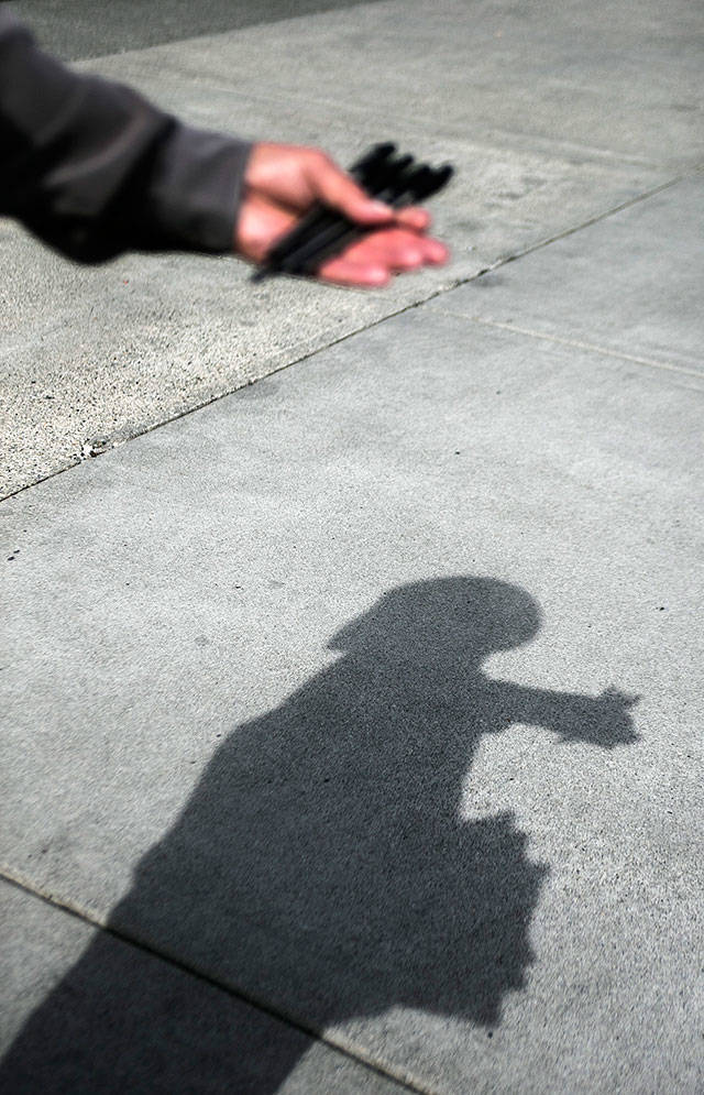 Mark Pitts attempts to stop people for signatures last week in Everett. (Olivia Vanni / The Herald)
