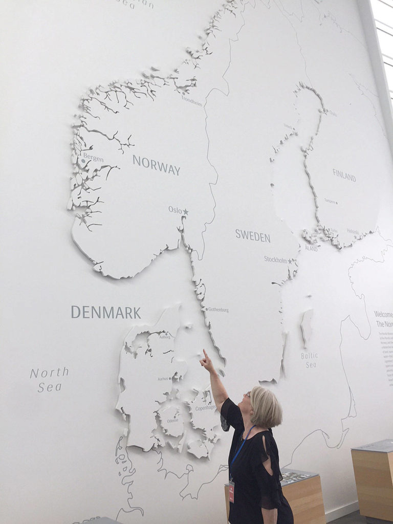The author’s mother, Betty Swaney, points to where her family emigrated from near Bergen, Norway, on the large map of Scandinavia at the Nordic Museum in Ballard. (Aaron Swaney)
