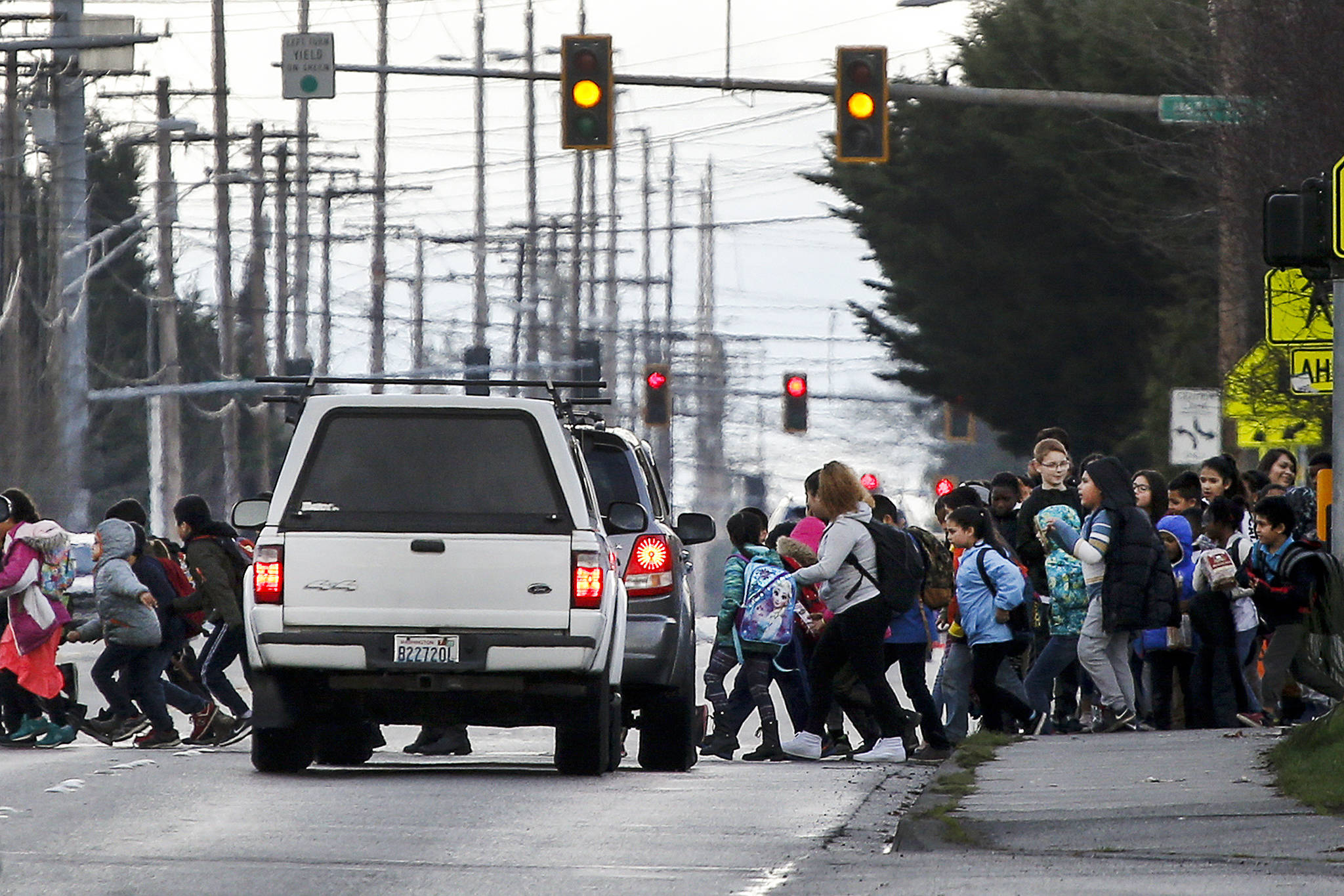 School kids cross Fourth Avenue W. near Voyager Middle School in Everett on Feb. 9. (Ian Terry / Herald file photo)