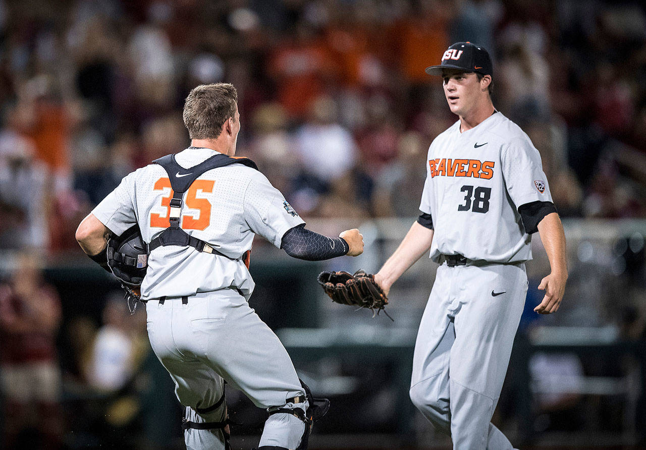 Oregon State pitcher Jake Mulholland (right), a Snohomish High School alum, celebrates with catcher Adley Rutschman after Oregon State beat Arkansas 5-3 in Game 2 of the College World Series finals on June 27, 2018, in Omaha, Neb. (Oregon State photo)