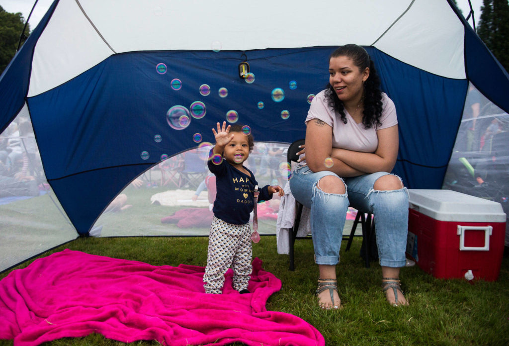Aleisha Ashton watches as Kira Griffin, 1, plays with bubbles before the start of the Thunder on the Bay Fireworks display on Wednesday. (Olivia Vanni / The Herald)
