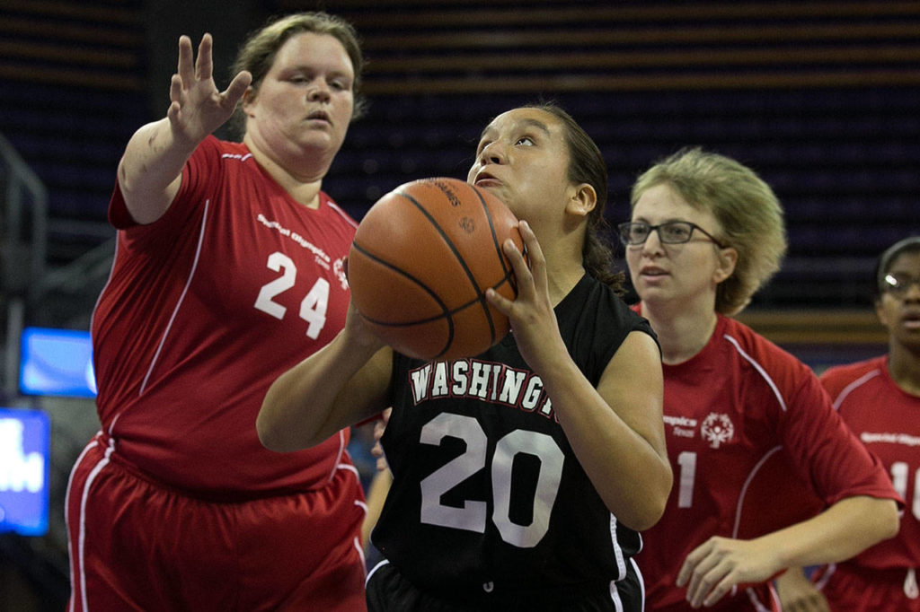 Washington’s Melany Hernandez (center) attempts a shot with Texas’ Stacey Hawkins (left) and Liane Matzenbach (right) trailing during the female basketball gold-medal game at the 2018 Special Olympics USA Games on July 5, 2018, at Alaska Airlines Arena in Seattle. (Kevin Clark / The Herald)
