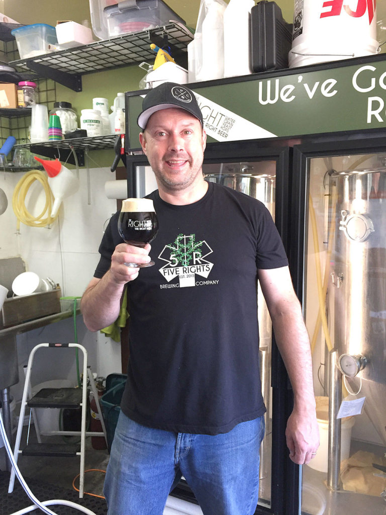 5 Rights Brewing owner and head brewer R.J. Whitlow holds a glass of the brewery’s Mr. O Coffee Oatmeal Stout anniversary beer. The beer, plus an imperial IPA, will be pouring at select locations around Snohomish County Saturday to celebrate 5 Rights’ third anniversary. (Aaron Swaney)
