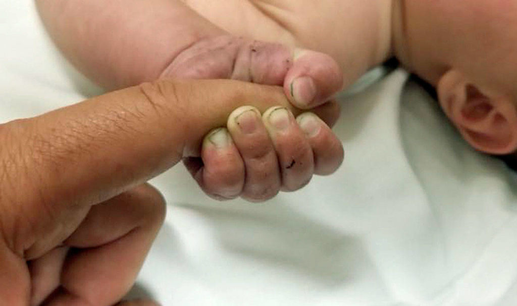 This 5-month-old infant with dirt under his fingernails survived about nine hours buried under sticks and debris in the woods. (Missoula County Sheriff’s Office via AP)
