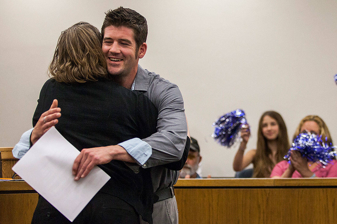 Eric Brossard receives a hug during Drug Court graduation as family and friends cheer in support at the Snohomish County Superior Court on Friday, July 13, 2018 in Everett, Wa. (Olivia Vanni / The Herald)