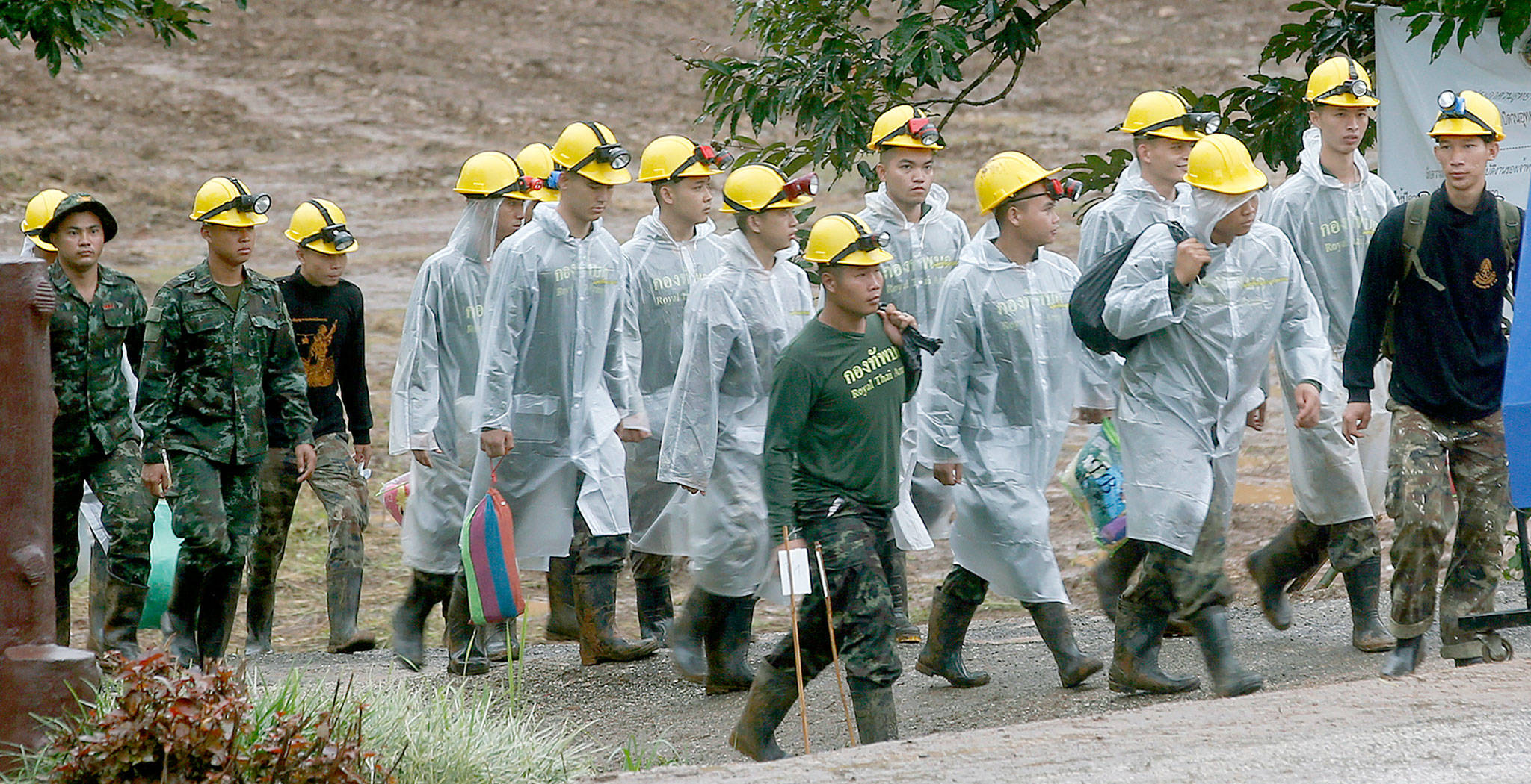 Rescuers walk toward the entrance to a Thailand cave complex on Tuesday where 12 boys and their soccer coach were trapped for more than two weeks. (AP Photo/Sakchai Lalit)