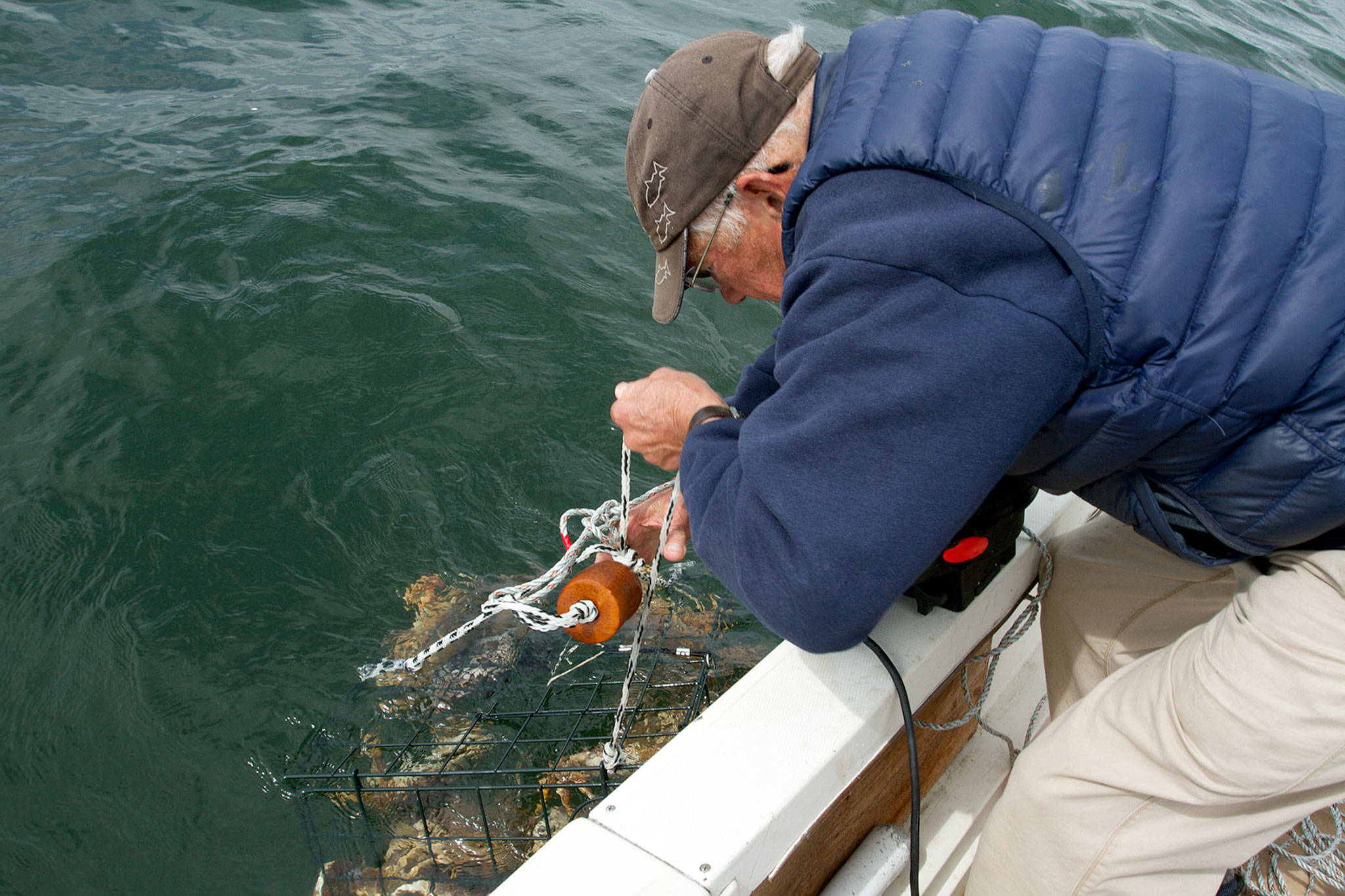 Jerry Solie of Everett pulls up a crab pot near Hat Island. (Mike Benbow photo)