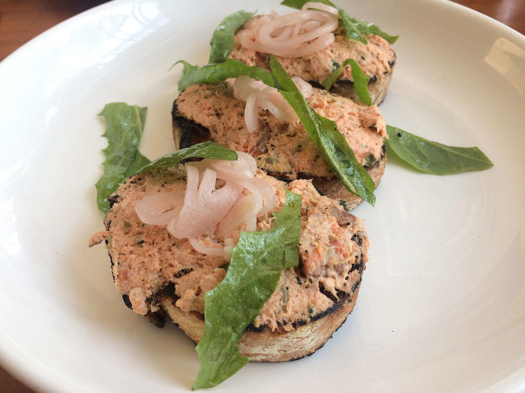 The bruschetta comes with smoked fish, pickled shallot, capers, dandelions and lemon on crunchy bread. Its among seven starter options at Everett’s Capers and Olives. (Evan Thompson / The Herald)
