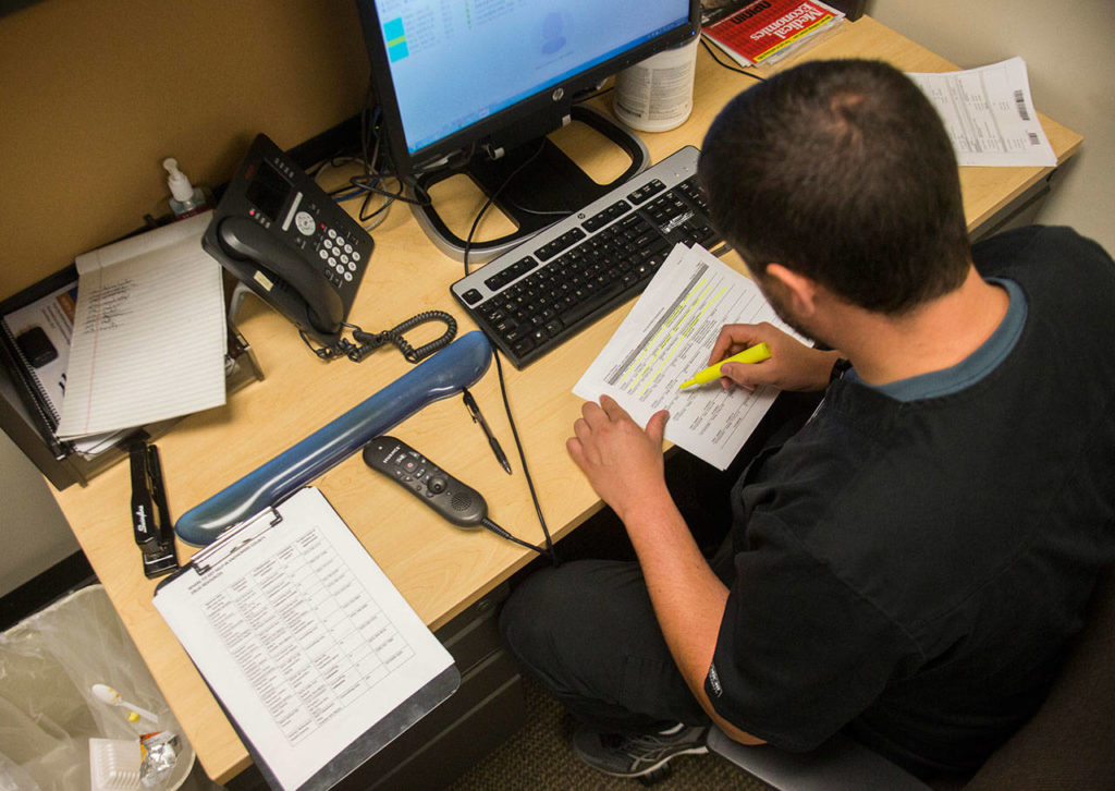 R.N. Eric Korsmeyer works on an opiod overdose report for a patient at the Providence Regional Medical Center Everett Colby Campus Emergency Department on Wednesday. (Olivia Vanni / The Herald)
