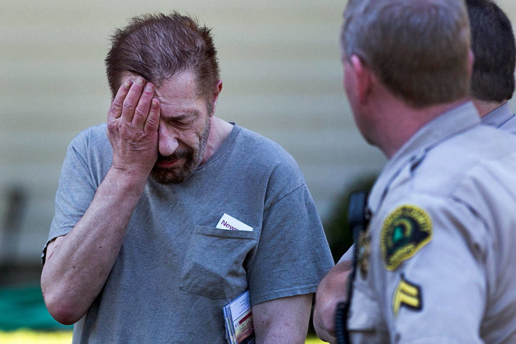 Mark Meinhardt listens as Snohomish County deputies explain the complaints against his property as a nuisance on July 11. (Kevin Clark / The Herald)
