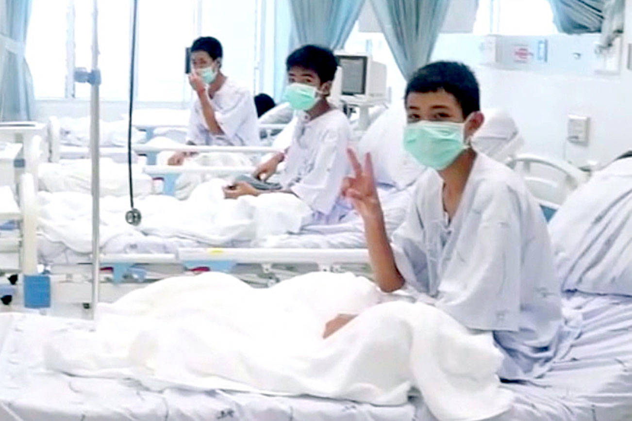 Rescued Thai boys make victory signs from hospital beds