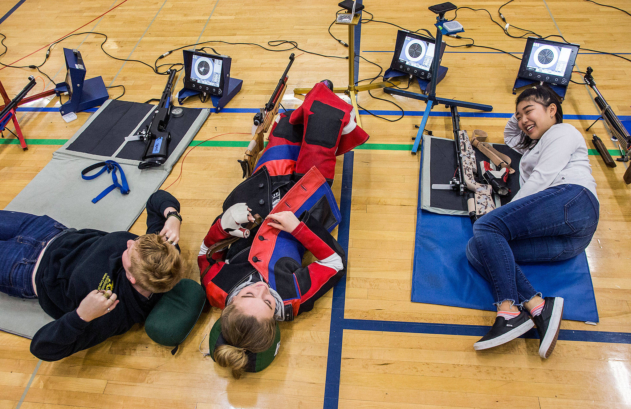 Kayla Dunham (from left), Jesse Brown and Reina Kim take a break during CMP Air Rifle Marksmanship Camp at Snohomish High School on Thursday. (Olivia Vanni / The Herald)