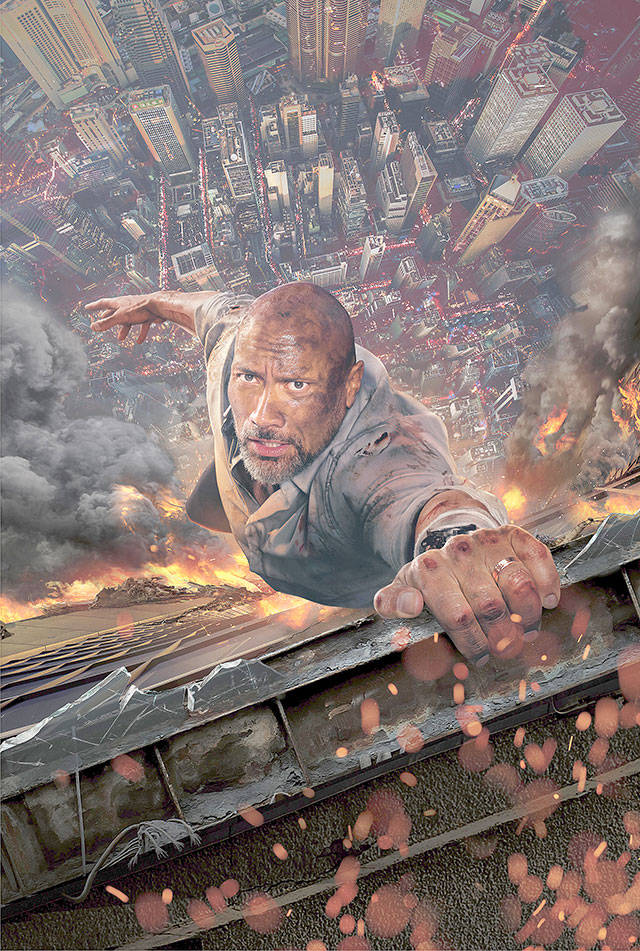 Dwayne “The Rock” Johnson hangs on by his fingertips in “Skyscraper.” (Universal Pictures)
