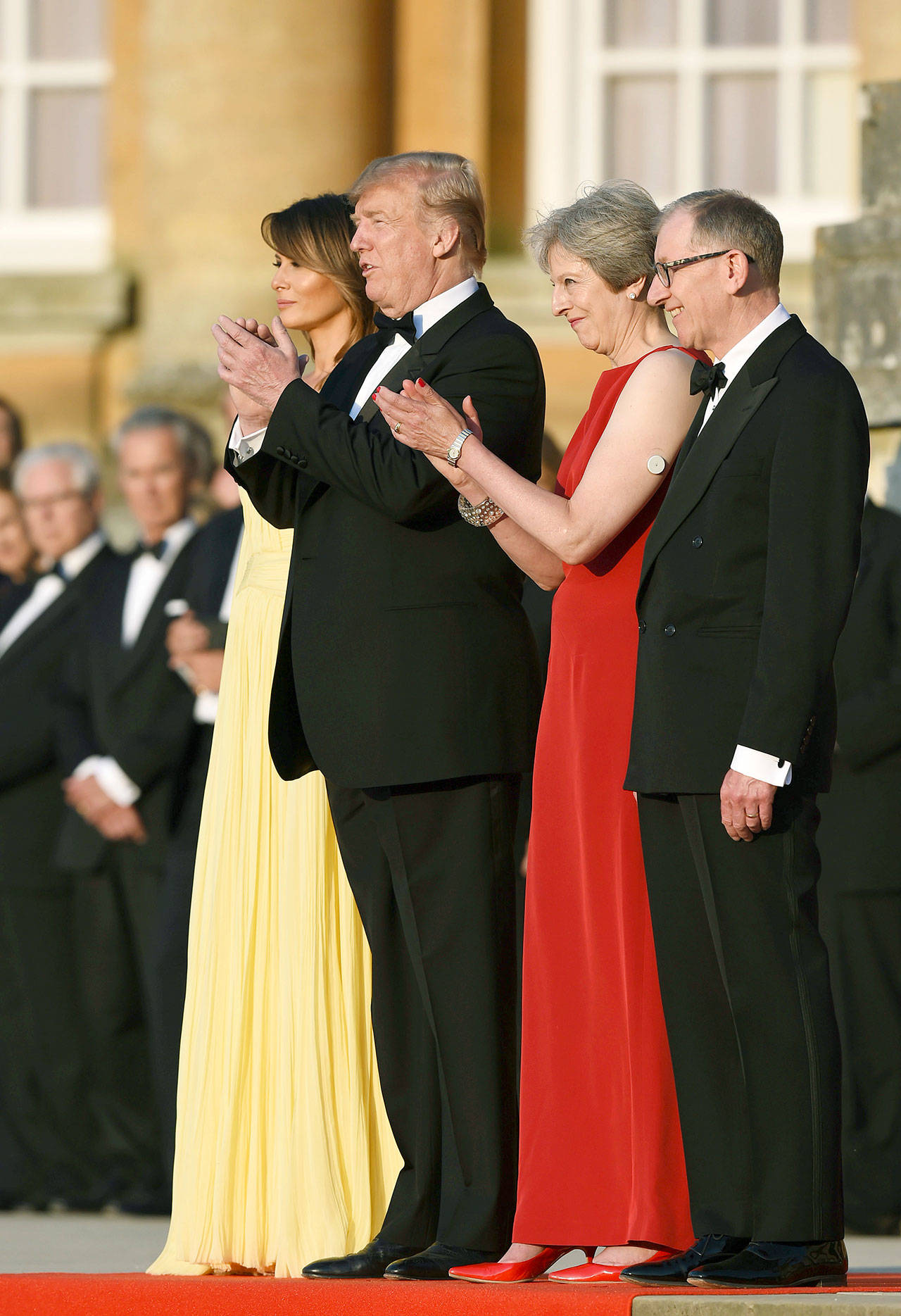 British Prime Minister Theresa May accompanied by her husband Philip, right, stand with U.S. President Donald Trump, and first lady Melania Trump, before a black tie dinner at Blenheim Palace, in Blenheim, England, Thursday, July 12, 2018. (Geoff Pugh/Pool via AP)