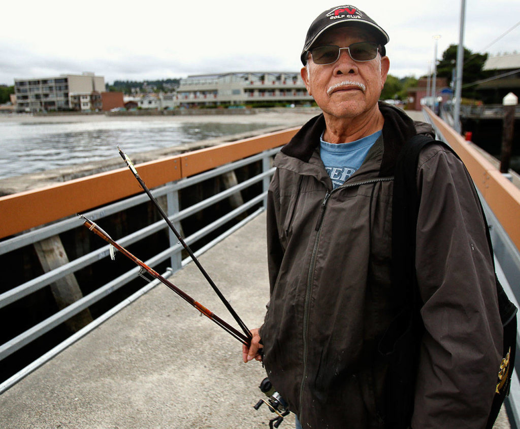 Ruben Rodriguez heads home to Seattle from the Edmonds fishing pier after several hours with no luck, but he said he will be back to try again soon. (Dan Bates / The Herald)
