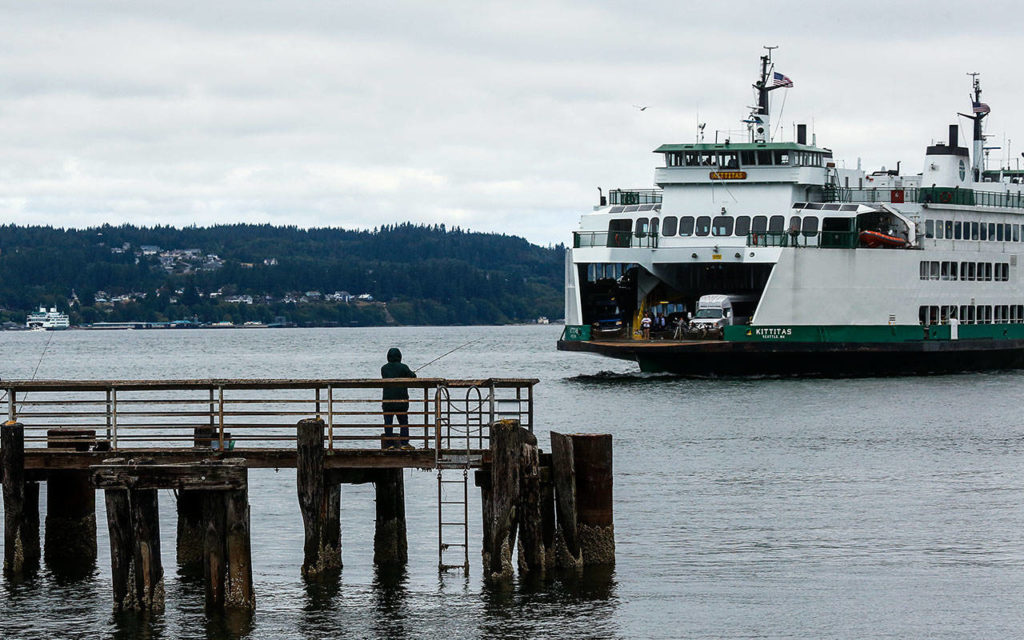 A fisherman waits for a catch at the fishing pier adjacent to the Mukilteo Ferry dock. (Dan Bates / The Herald)
