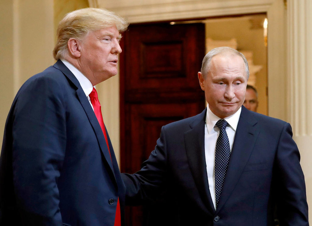 U.S. President Donald Trump (left) and Russian President Vladimir Putin leave a press conference after their meeting at the Presidential Palace in Helsinki, Finland, on Monday. (AP Photo/Pablo Martinez Monsivais) 
