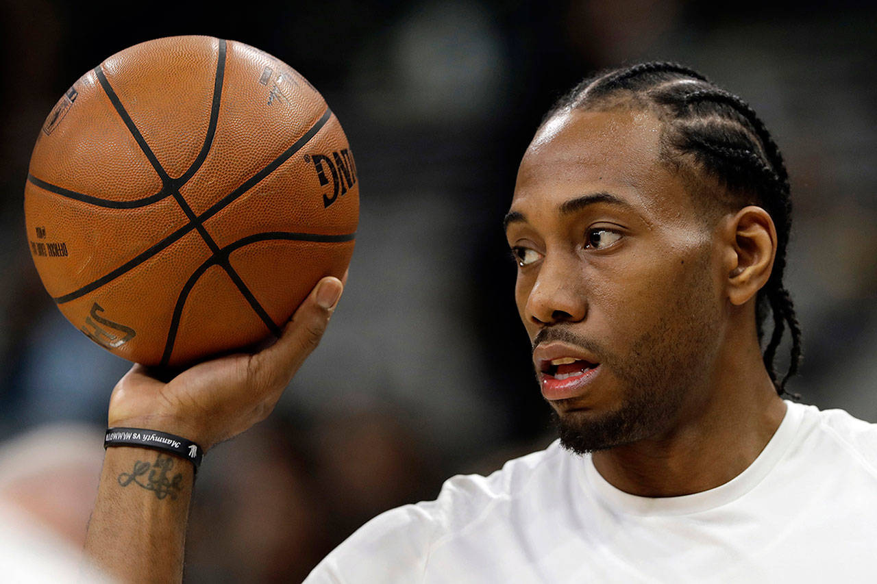 In this Jan. 5, 2018, file photo, San Antonio Spurs forward Kawhi Leonard handles a ball before an NBA game against the Phoenix Suns in San Antonio. (AP Photo/Eric Gay, File)