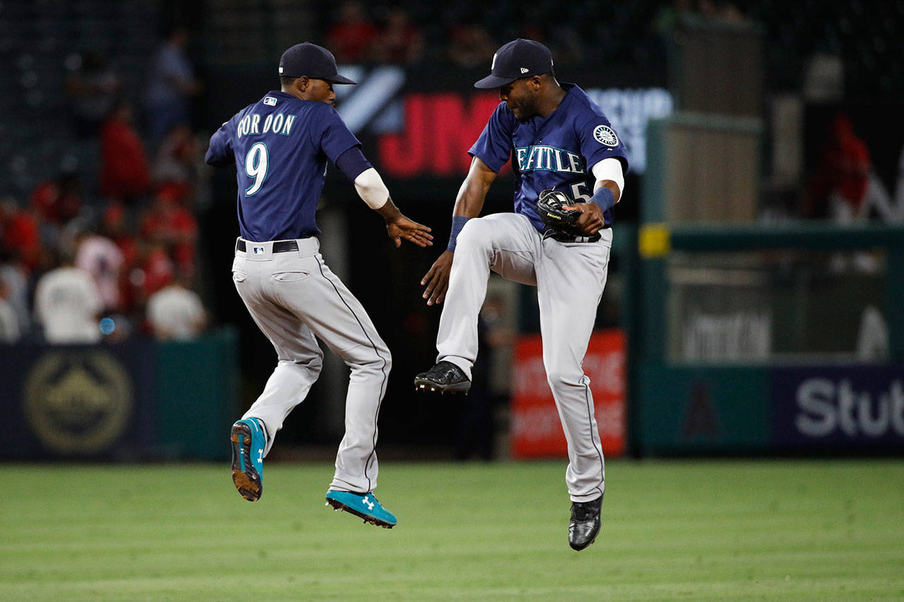 The Mariners’ Dee Gordon (left) and Guillermo Heredia celebrate a 3-0 win over the Angels on July 11, 2018, in Anaheim, Calif. (AP Photo/Jae C. Hong)