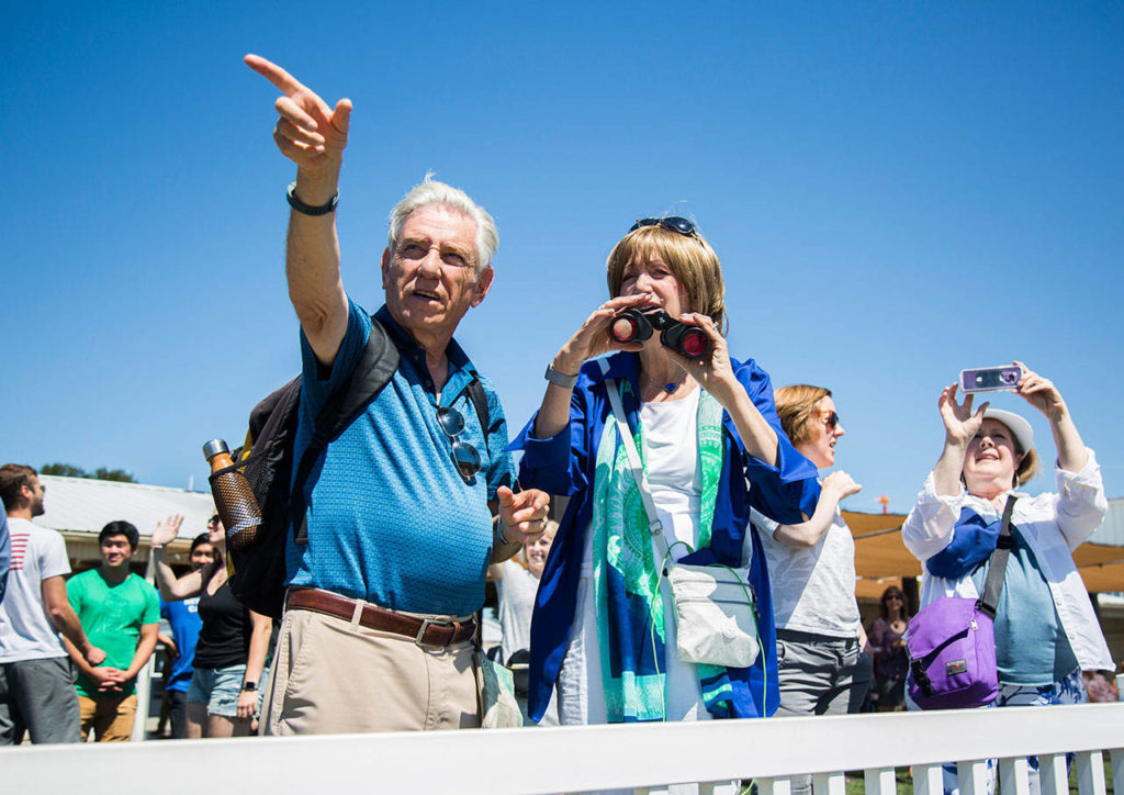 Len Gardener and Marilyn Gardner, family of Stu Williamson, point as the plane takes off before 100-year-old Williamson’s skydive at Skydive Snohomish on Sunday. (Olivia Vanni / The Herald)
