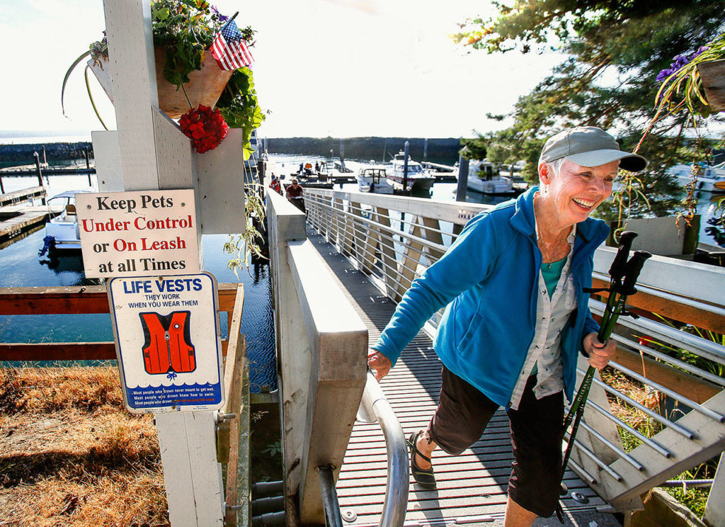 Donna Lemke walks up the marina ramp at Hat Island Thursday. Lemke, 77, loves to swim in the saltwater off the island, where she has had a place since 1990. She also has a home on Lake Sammamish. (Dan Bates / The Herald)

