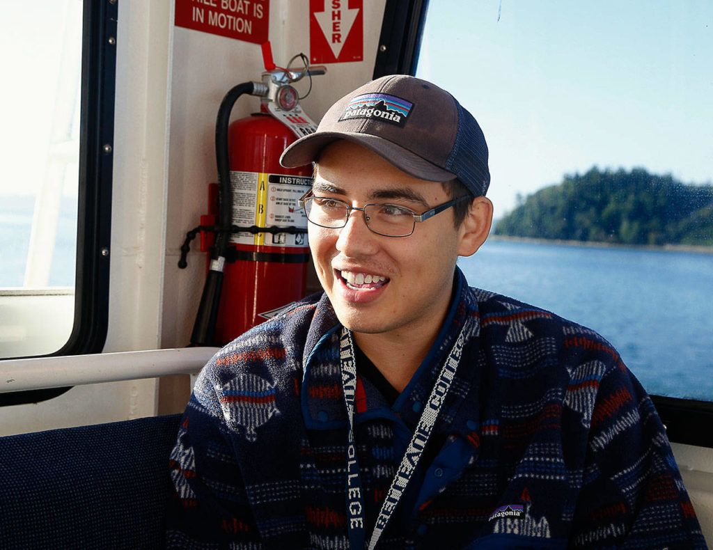 Carlos Snellenberg rides the Hat Express out to the island Thursday morning. The 21-year-old has been going to Hat Island all his life. His late grandfather, Wally Snellenberg, was one of 12 property owners who developed the island in the 1960s. Wally Snellenberg and other developers envisioned a resort mecca called “Hat Island Riviera.” (Dan Bates / The Herald)
