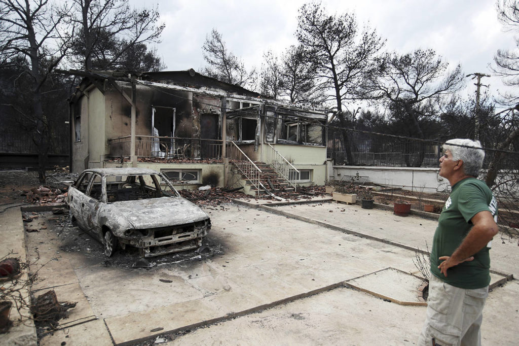 A man looks the burned house of his sister in Agios Andreas, east of Athens, on Tuesday. (AP Photo/Thanassis Stavrakis)
