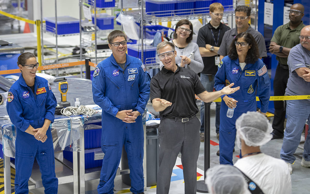 Chris Ferguson (center) and (from left) NASA astronauts Nicole Mann, Bob Behnken and Sunita Williams talk with Boeing employees after they assembled part of the Starliner spacecraft. (Jonathan Newton/Washington Post)