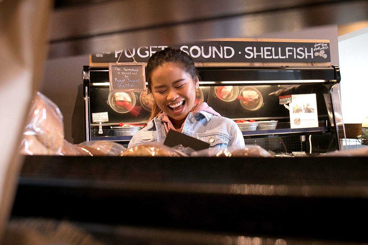 Andrea Guerrero shares a laugh at Farms & Market, which opened in March in Everett. (Kevin Clark / The Herald)