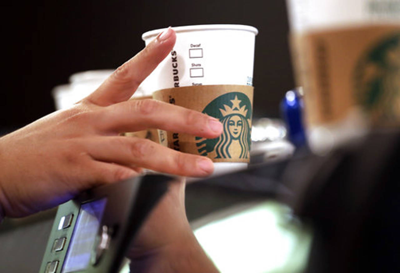 In this May 29 photo, a barista reaches for an empty cup at a Starbucks in the Pike Place Market in Seattle. (AP Photo/Elaine Thompson, File)