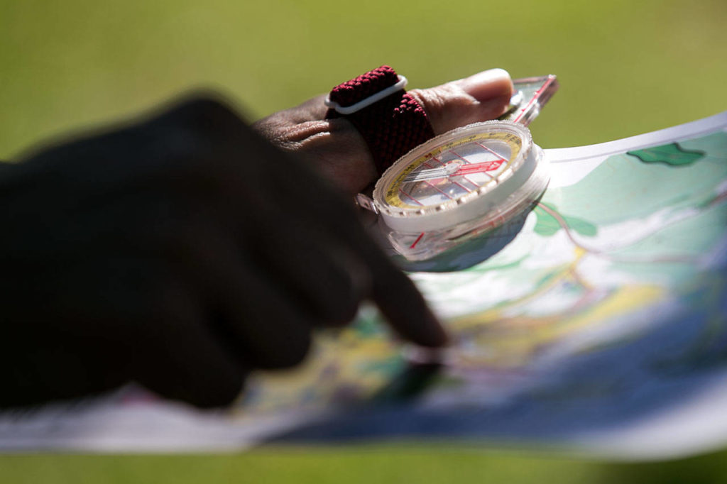 Herald sports writer Nick Patterson looks at a map of the orienteering course at Forest Park in Everett on July 18. (Kevin Clark / The Herald)
