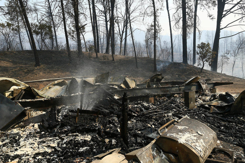 The remains of a home burned by a wildfire is seen Thursday in Whiskeytown, California. California Gov. Jerry Brown has declared states of emergency in Riverside and Shasta counties as fires burn on both ends of the state. The declarations issued Thursday state that hot temperatures, erratic wind and low humidity have increased the spread of both fires. (Hung T. Vu/Record Searchlight via AP)
