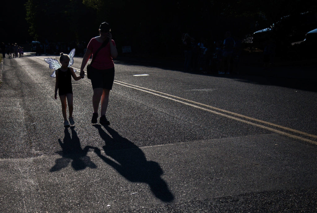 Kristen Falk, 6, holds her mom’s hand before the start of the Tour de Terrace parade on Friday, July 27, 2018 in Mountlake Terrace, Wa. (Olivia Vanni / The Herald)
