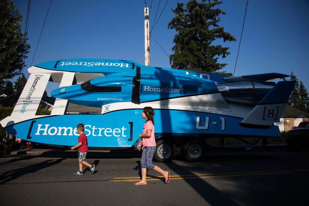 Children run past the HomeStreet Bank hydroplane before the start of the Tour de Terrace parade on Friday, July 27, 2018 in Mountlake Terrace, Wa. (Olivia Vanni / The Herald)
