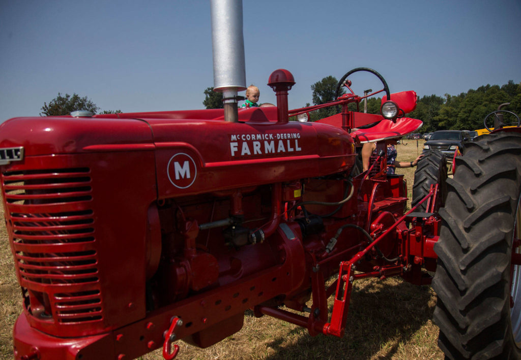 Castiel Knowlston, 1, looks at tractors from his father’s shoulders during the Silvana Fair off of Pioneer Highway on Saturday, July 28, 2018 in Silvana, Wa. (Olivia Vanni / The Herald)
