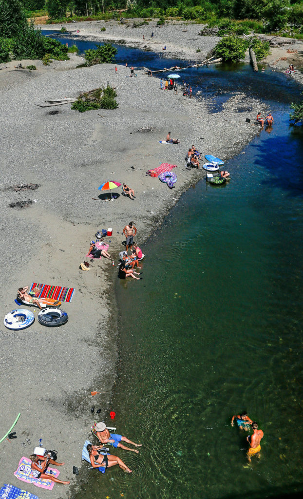 Beginning early last week, people could be seen up and down and in the Pilchuck River at Dubuque Road, just off Machias Road, and just about anywhere else access to the cool waters could be found. (Dan Bates / The Herald)
