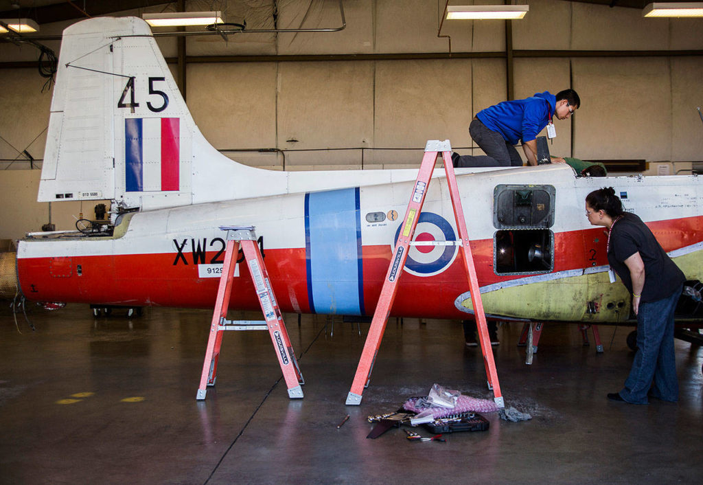 Daniel Zaragoza and Kareen Vincent inspect a BAC Jet Provost during class at Everett Community College’s Aviation Maintenance Technician School on Friday, July 13, 2018 in Everett, Wa. (Olivia Vanni / The Herald)

