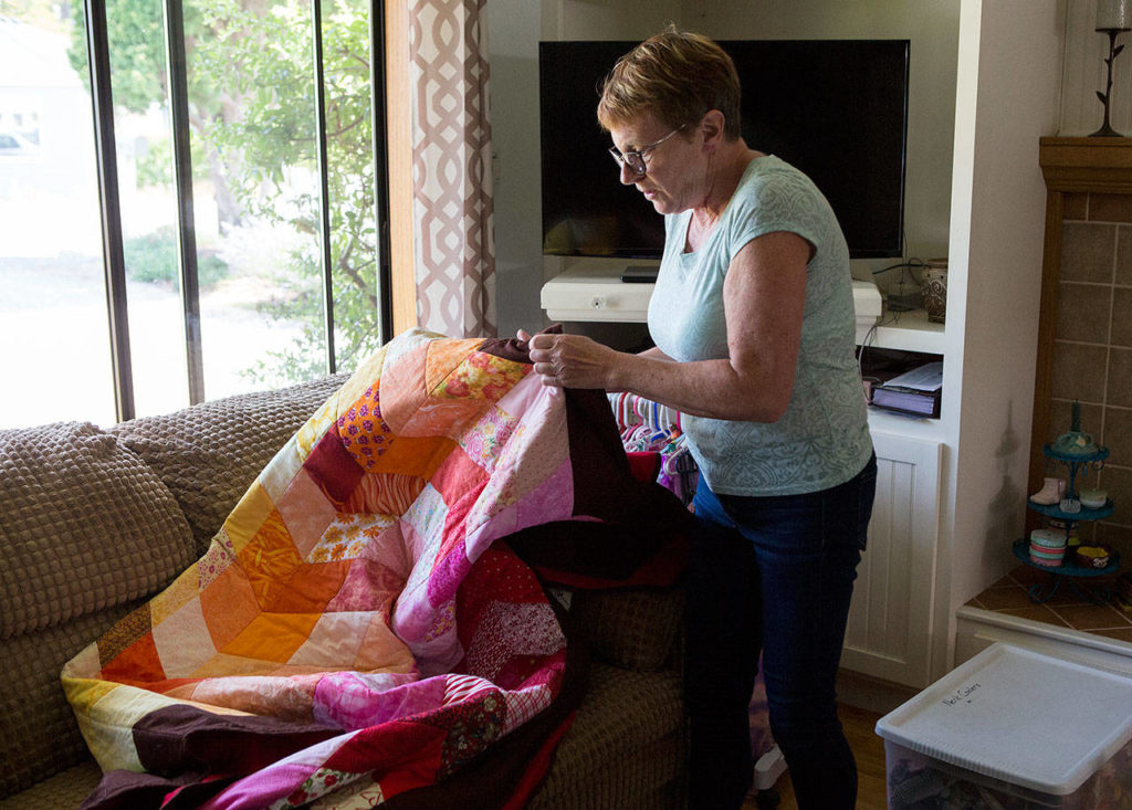 In her Everett home, Summer Rae Dolman’s Grandmother Liz Stevenson shows a quilt that was made in memory of her grandchild. Summer killed herself in April. The quilt includes a heart-shaped patch signed by her friends. (Andy Bronson / The Herald)
