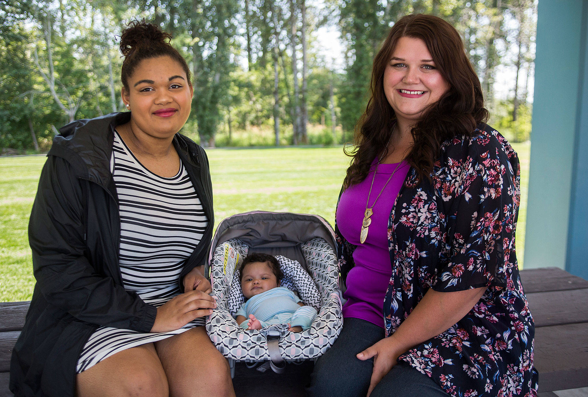 Abigail Hulce, 19, left, with daughter, Kya Lankford, 2 months, and PEPS group leader Holly McCallum at Lundeen Park on July 27 in Lake Stevens. (Olivia Vanni / The Herald)