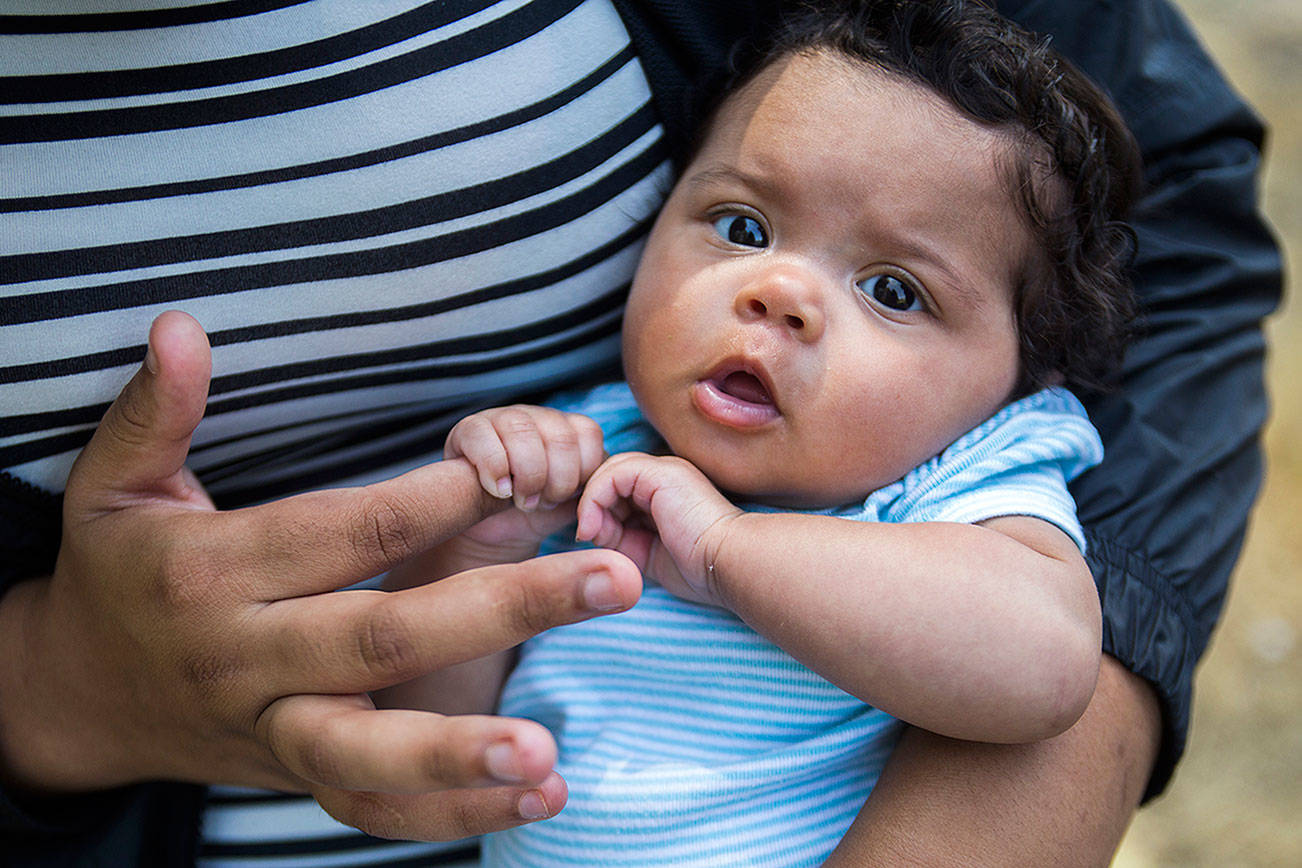 Kya Lankford, 2 months, holds onto her mother’s finger at Lundeen Park on Friday, July 27, 2018 in Lake Stevens, Wa. (Olivia Vanni / The Herald)