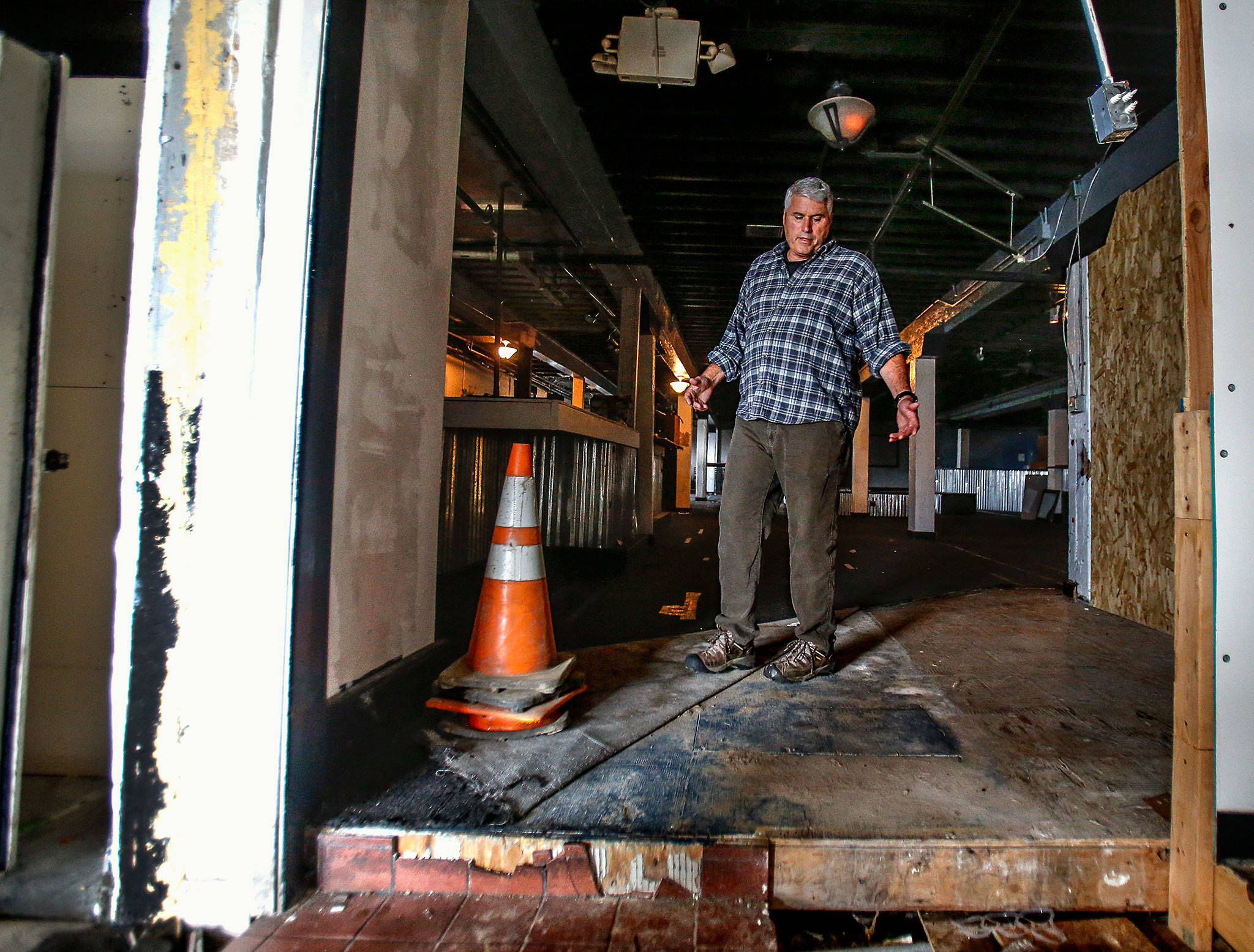 Chandler Williamson, a board member of the Everett Recovery Cafe, points out that some work that needs to be done to the lower level of the old Everett Public Market before it can become the cafe’s new home. (Dan Bates / The Herald)