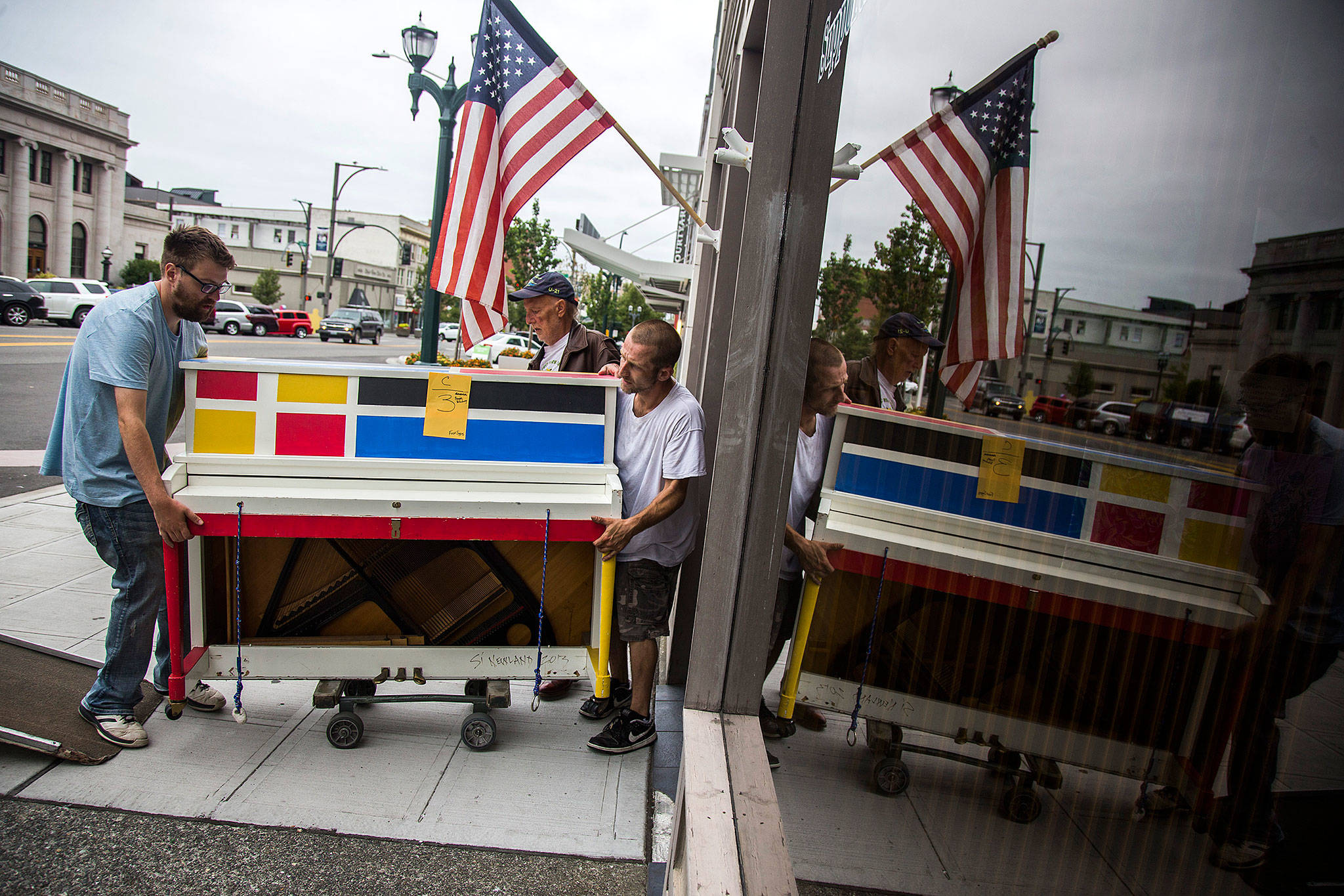 Robert Alkire (left), Michael Alkire and Dan DeMascio of Piano and Organ Moving Co. Inc. move the Broadway Boogie Woogie piano into their moving van on Aug. 1 for Everett’s Street Tunes. (Olivia Vanni / The Herald)